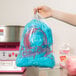 A person holding a Carnival King cotton candy bag filled with blue cotton candy.