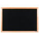 A black felt Aarco message board with a wooden frame.