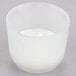 A white wax candle in a glass cup.