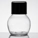 A clear glass jar with a black top.