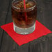 A glass of iced tea sitting on a Classic Red beverage napkin.