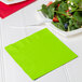 A Fresh Lime green napkin with a bowl of salad and a fork on a white plate.