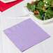 A plate of salad with a Creative Converting luscious lavender napkin on it.