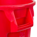 A red Rubbermaid BRUTE round trash can with a handle.