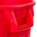 A red Rubbermaid BRUTE trash can with handles.