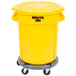 A yellow Rubbermaid BRUTE trash can with lid and dolly.