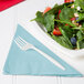 A plate of salad with strawberries, spinach, and blueberries with a Creative Converting pastel blue luncheon napkin on the side.
