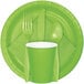 A green 1/4 fold luncheon napkin with a fork and spoon on a white rectangular plate.