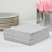 A stack of Creative Converting Shimmering Silver luncheon napkins.