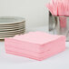 A stack of Classic Pink Creative Converting luncheon napkins.