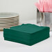 A stack of Hunter Green 1/4 Fold Luncheon Napkins on a table