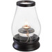 A Sterno Draper clear glass lantern with a flame inside.