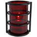 A Sterno red glass candle holder with a flame in it.