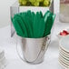 A bucket filled with green Creative Converting plastic knives.