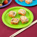 A sushi roll on a Creative Converting Fresh Lime Green paper plate.