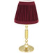 A burgundy lamp shade on a gold Sterno La Rue lamp base.
