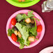 A close-up of a plate of salad with tomatoes and croutons on a table.