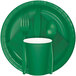A close up of an emerald green paper plate with a fork, spoon, and cup on it.