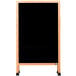 An Aarco A-Frame sidewalk board with a black porcelain board and wooden frame.