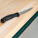 A black-handled knife on a green Cactus Mat shelf liner.