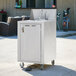 A Crown Verity portable hand sink cart with three sinks on a counter outdoors.