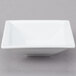 A Libbey white square porcelain fruit bowl on a gray surface.