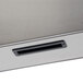 A close-up of a metal drawer with a slot.