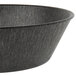 A black polyethylene round basket with a gray rim on a counter.