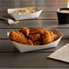 A white customizable paper food tray with fried chicken on a table.