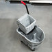 A gray Rubbermaid Executive WaveBrake mop bucket with a handle on top.