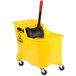 A yellow Rubbermaid mop bucket with a black handle on wheels.
