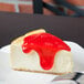 A slice of cheesecake with Lucky Leaf strawberry glaze on top.