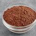 A bowl of Regal Dutch cocoa powder on a gray surface.