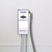 A silver Dema ProFill 651AG2 chemical dispenser box attached to a wall with a black hose.