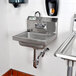 A Regency chrome P-trap under a sink with a faucet.