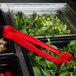 Red Thunder Group flat grip tongs being used in a salad container on a salad bar counter.