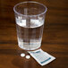 A glass of water and Medi-First Ibuprofen tablets on a table.