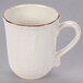 A white stoneware mug with a brown rim and handle.