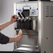 A person using a Spaceman soft serve ice cream machine to make ice cream.