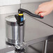 A person using a Vollrath Redco EaziClean heavy duty can opener with a black handle.