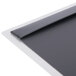 A Menu Solutions Alumitique aluminum menu board with top and bottom strips on a black surface.
