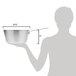 A woman using a measuring cup to pour into a Vollrath Arkadia sauce pan.
