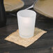 A frosted glass candle on a table.