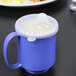 A clear polypropylene lid on a blue cup.