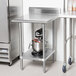 A stainless steel Advance Tabco work table with a mixer on it.