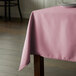 A rectangular pink Intedge table cloth on a table.
