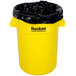 A yellow plastic Continental trash can with a black bag inside.