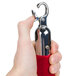A hand holding a red metal hook with chrome ends.