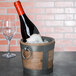 A bottle of wine in a 10 Strawberry Street Telluride wooden wine bucket with ice.