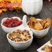 A 10 Strawberry Street Whittier white porcelain bowl caddy filled with bowls of nuts and dried fruits.